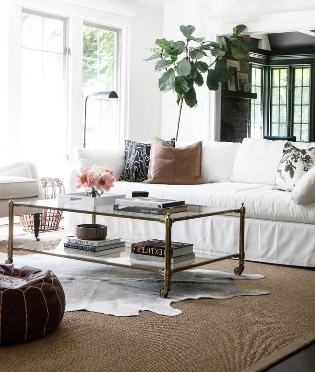 A Black And White Cowhide Rug Is Layered Atop A Bound