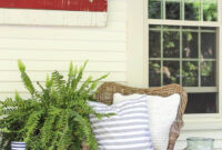 A Charming Farmhouse Covered Porch Is Decorated For Summer