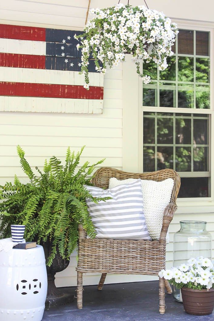 A Charming Farmhouse Covered Porch Is Decorated For Summer