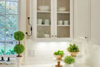 This Classic White Kitchen With Fresh Accents And Open Glass Louvered Cabinets And Sub