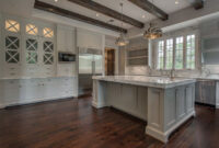 White And Gray Kitchen Features A Tray Ceiling Lined With
